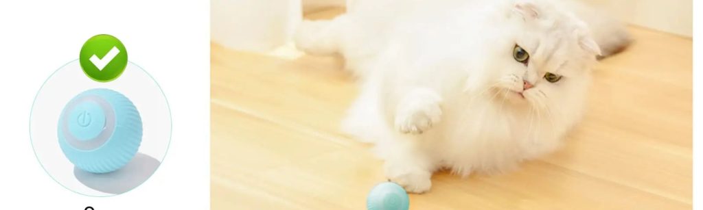 A white cat is playing with a blue ball that has a white light on it. The cat is batting at the ball with its paws.